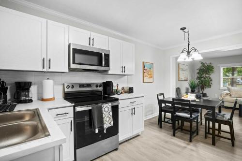 una cocina con fregadero y estufa horno superior en 10 Min to Downtown - Smart Tvs - Fast Wi-Fi, en Raleigh