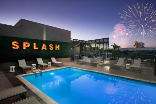 a swimming pool in front of a building with fireworks at SpringHill Suites by Marriott at Anaheim Resort Area/Convention Center in Anaheim