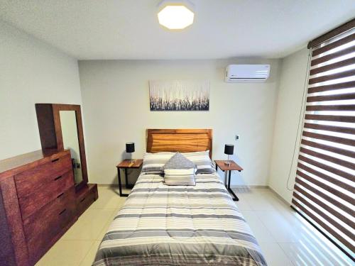 a bedroom with a large bed and two night stands at Hogar Tu Santuario Uruapan in Uruapan del Progreso