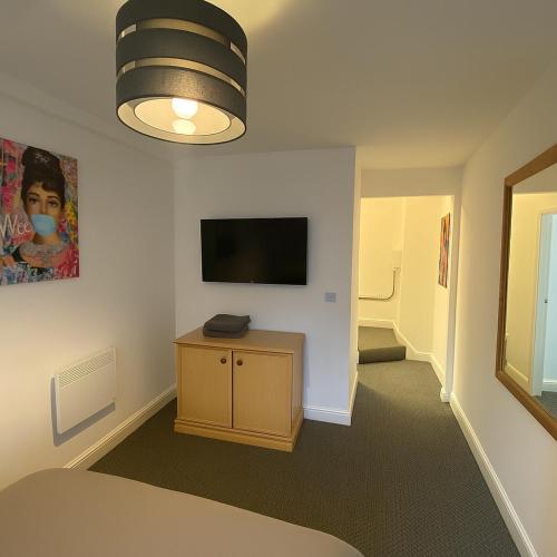a room with a bed and a television on a wall at LT 3 - 1 Bed Apartment - Free Street Parking in Leicester