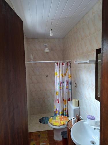 a bathroom with a shower and a toilet and a sink at Casa entre a praia do Curral e cachoeira in Ilhabela