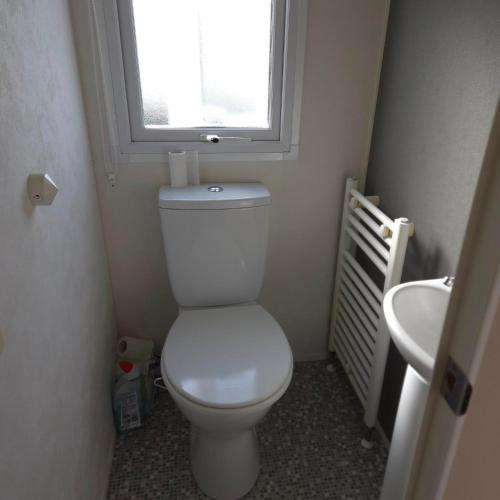 a small bathroom with a toilet and a window at Coastal Retreats in Great Clacton