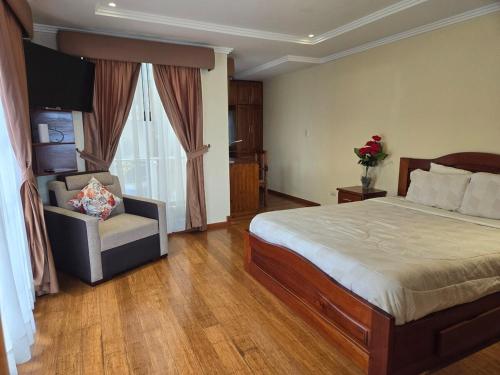 um quarto com uma cama, uma cadeira e uma janela em Horizonte Mágico full suite em Cuenca