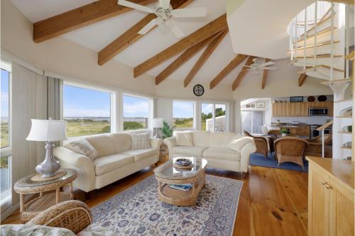 a living room with white couches and a table at Dune Crest Hotel in North Truro