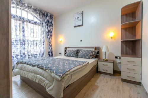een slaapkamer met een bed en een groot raam bij The White Residence Kigali in Kigali