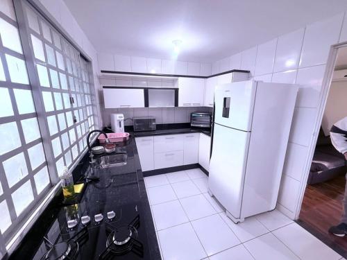 a kitchen with a white refrigerator in a room at Casa Aconchegante in Foz do Iguaçu