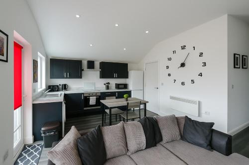 a living room with a couch and a clock on the wall at LT 3 - 1 Bed Apartment - Free Street Parking in Leicester