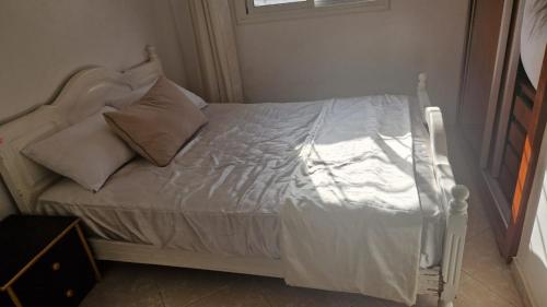 a bed with white sheets and pillows in a bedroom at Appart hôtel tanger in Tangier
