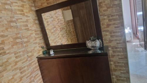 a bathroom with a mirror on a brick wall at Appart hôtel tanger in Tangier