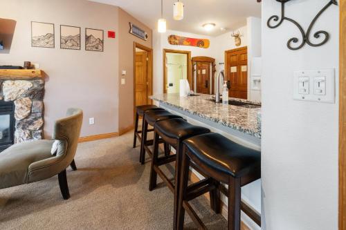a kitchen with a long bar with leather stools at Gateway Mountain Lodge by Keystone Resort in Keystone
