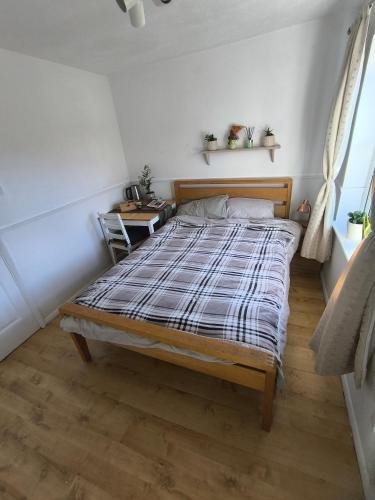 a bedroom with a bed with a plaid blanket at Angelo's home in London