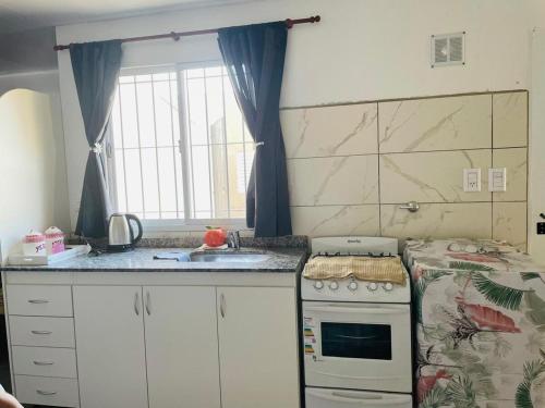 a kitchen with a stove and a sink and a window at Apartment with garage, for 4 people, 3 blocks from the Hospital in RSA
