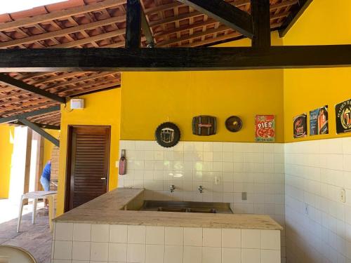 eine Küche mit Spüle und gelber Wand in der Unterkunft Casa de Praia em Paripueira in Paripueira