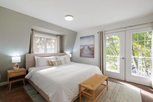 a bedroom with a large white bed and windows at Hood Canal Escape- upscale meets the rocky shores! in Belfair