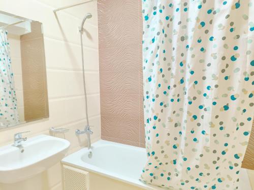 a bathroom with a sink and a shower curtain at Appartements Rihana Family Only in Tangier