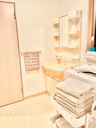 a white bathroom with a sink and a washing machine at バス停"平城札所前"徒歩0分 四国愛媛の宿 "40番たっきゅうミニホテル" "No40 Takkyu mini hotel" in Hirajō