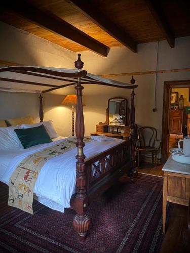 a bedroom with a large wooden canopy bed with a mirror at De Dapper Huys in Philadelphia