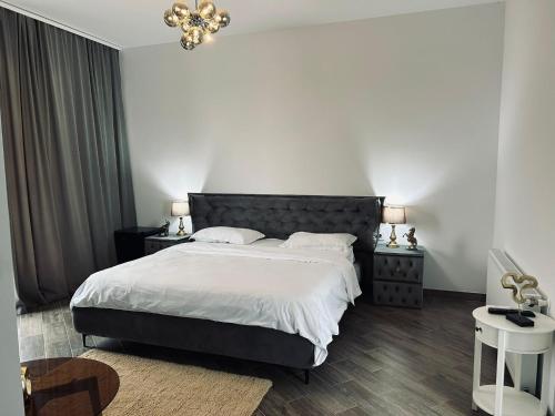 a bedroom with a large bed and a chandelier at Pensiunea Gloria in Afumaţi