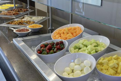 Una línea de buffet con tazones de diferentes frutas y verduras. en West Des Moines Marriott, en West Des Moines