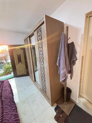 a bedroom with a large wooden cabinet with a towel at petra towering rock in Wadi Musa