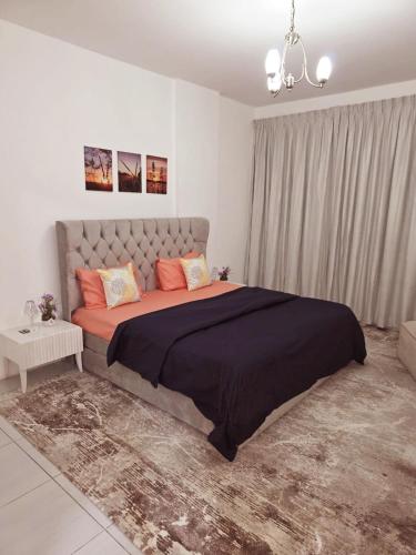 a bedroom with a large bed with orange pillows at Beautiful 3-bedroom Family Apartment near Buhaira Corniche in Sharjah