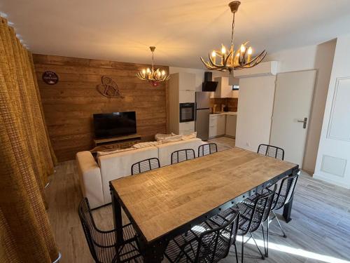 a dining room and living room with a table and chairs at chalet Des Cimes de Risoul in Risoul