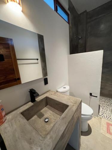 łazienka z betonową umywalką i toaletą w obiekcie Casa Jubilee 6 two twins or king w mieście Puerto Escondido
