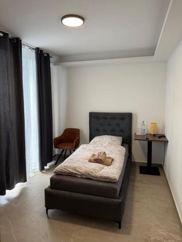 a bedroom with a bed and a table and a chair at Hotel Akropolis in Herford
