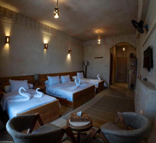 a hotel room with two beds and chairs in it at Breezy island Hotel in Siwa