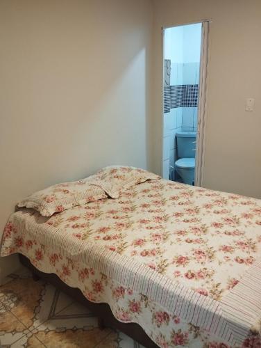 Un dormitorio con una cama con una colcha floral. en Residencial Humberto Mendes, en Belém