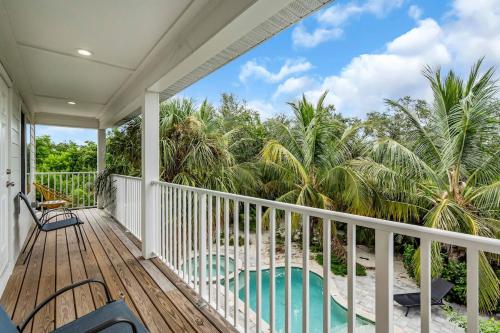 ブレーデントンにあるBradenton Stay, Private Pool, HotTub, Priv Terraceの椰子の木とビーチを望むポーチ