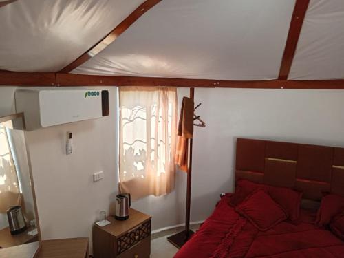 a bedroom with a red bed and a window at petra towering rock in Wadi Musa