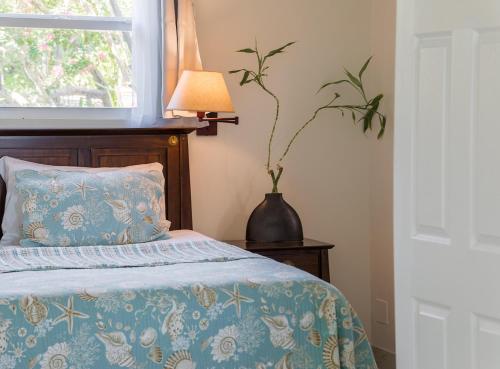 a bedroom with a bed with a lamp and a window at Esencia Premiere in Providenciales