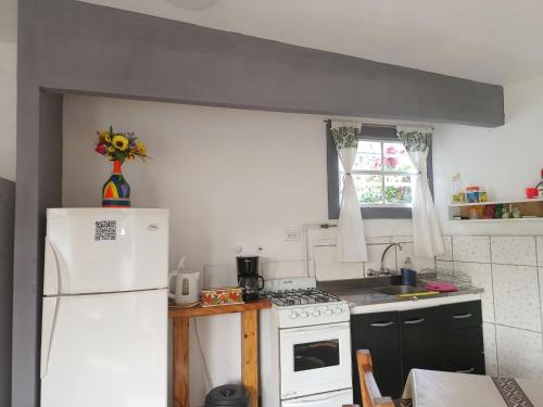 Una cocina con un refrigerador blanco y un fregadero. en Departamento Familiar con estacionamiento incluido, en Bahía Blanca