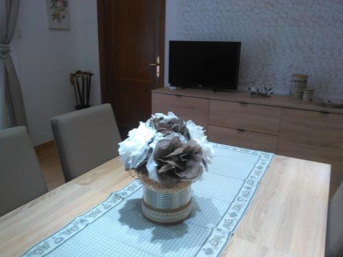 a vase of flowers sitting on a table with a television at Appartamento Grey in Arezzo