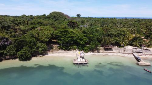 an island with a boat in the middle of the water at Hotel Isla Fuerte Ecohouse in Puerto Limón