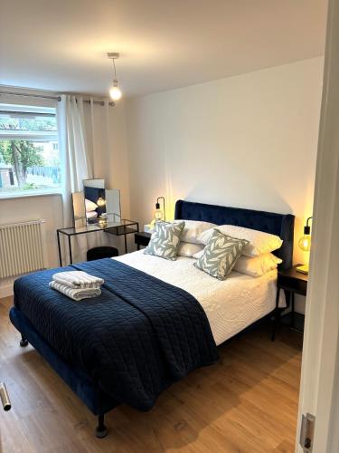 a bedroom with a large bed with a blue blanket at Modern Flat In Penge - 3 person in Elmers End