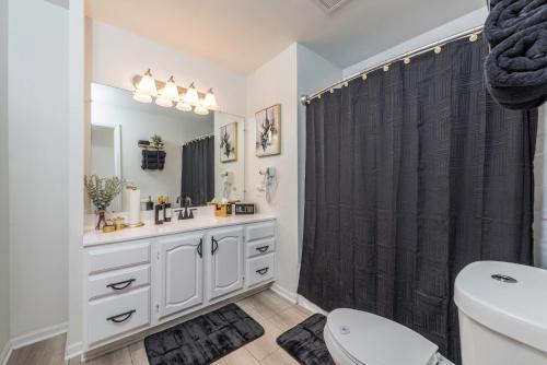 a bathroom with a black shower curtain and a sink at Cottingham Cottage in Zion