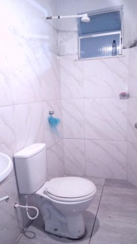 a white bathroom with a toilet and a sink at Apartamento COP 30 in Belém