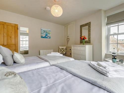 Un dormitorio con dos camas y un espejo. en 2 Bed in Polruan 91396, en Fowey