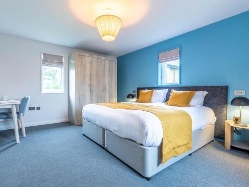 Un dormitorio con una cama grande con paredes azules. en 2 Bed in St. Mellion 87705, en St Mellion