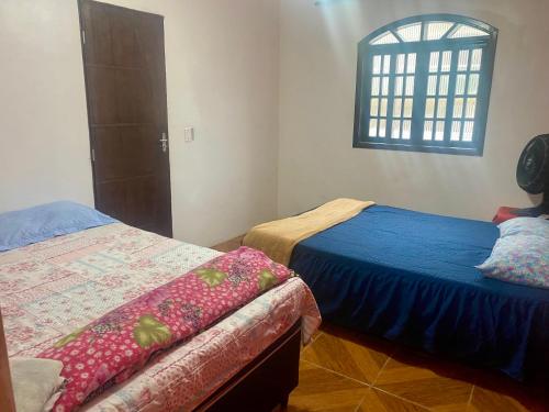 a bedroom with two beds and a window at Casa Pôr do Sol Angra in Angra dos Reis