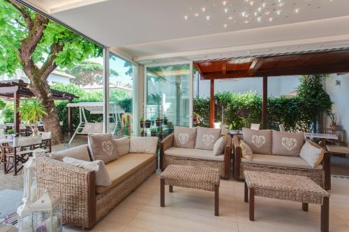 a patio with two couches and a table and chairs at B&B Airone Cervia - Camere e Appartamenti in Cervia