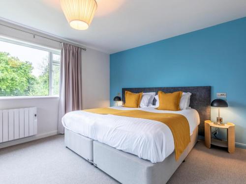 Un dormitorio con una cama grande con una pared azul. en 2 Bed in St. Mellion 87709, en St Mellion