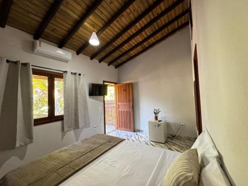 a bedroom with a bed in a room with a window at Pousada Arraial dos Sonhos in Arraial d'Ajuda