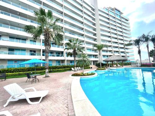 CarolinaBeach front Ocean view, pool Family Apt Salinas的一座大型公寓楼,设有游泳池和棕榈树