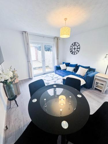 a living room with a table and a blue couch at Modern 2-Bed w Parking & Garden in Woolwich