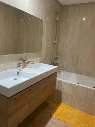 a bathroom with a white sink and a bath tub at Luxury Stay Rabat Serenity in Rabat