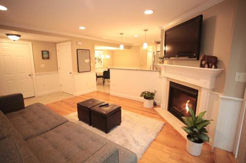 a living room with a fireplace with a tv above it at Peaceful 2BR near US Route 1 and Boston in Melrose