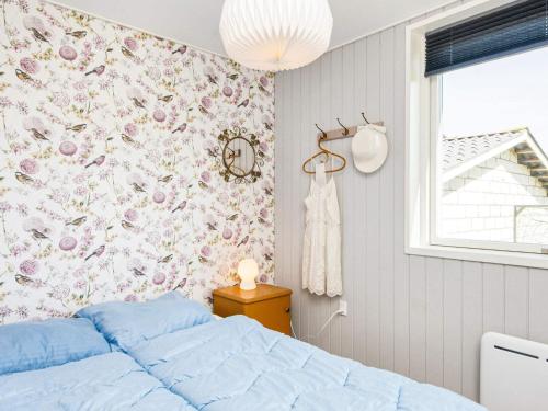 a bedroom with a bed and a floral wallpaper at 6 person holiday home in Augustenborg in Augustenborg